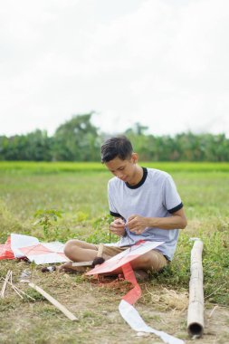 Genç adam uçurtma halatı yapıyor.