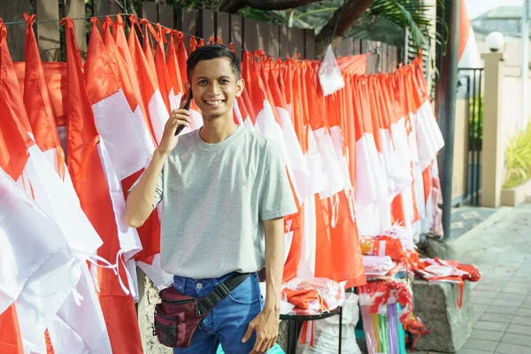 Porträtt av en ung man som säljer flaggor som tar order — Stockfoto