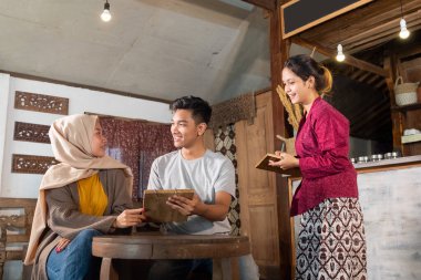 Genç çift menüyü seçiyor.