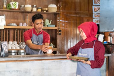 Adam içkiyi garsonlara veriyor.