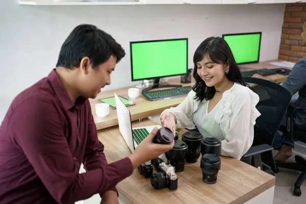 Обслуговування клієнтів пояснює продукт на магазині обладнання для камери — стокове фото