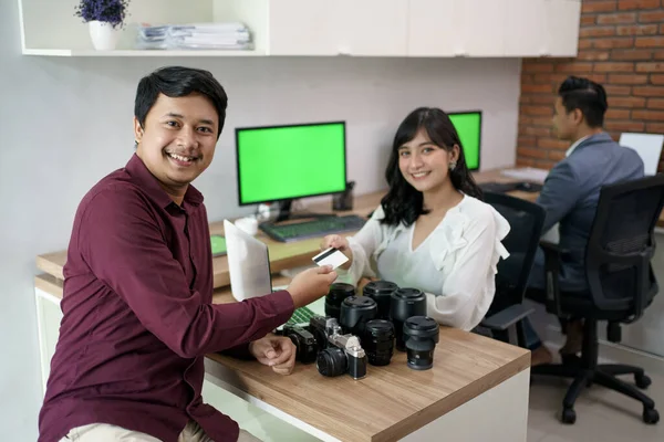 Cliente pagare il conto con carta di credito sul negozio noleggio macchina fotografica — Foto Stock