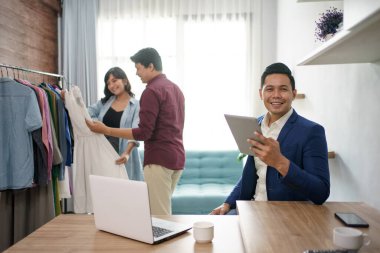 Giysi koleksiyonu olan bir butik sahibinin portresi