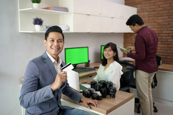 Kunde bezahlt die Rechnung mit Kreditkarte im Kameraverleih — Stockfoto