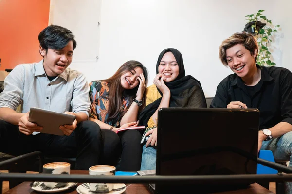 Skupina usměvavých teenagerů drží pohromadě pomocí gadgetu — Stock fotografie