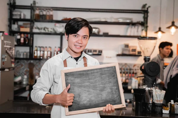 Barista houdt een schoolbord en duimen omhoog — Stockfoto