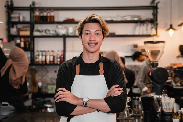 Barista steht mit verschränkten Händen vor einem Café — Stockfoto