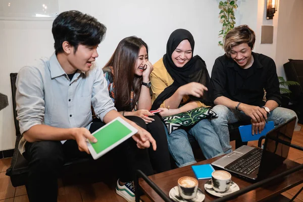 Groupe d'adolescents souriants restant ensemble en utilisant gadget — Photo