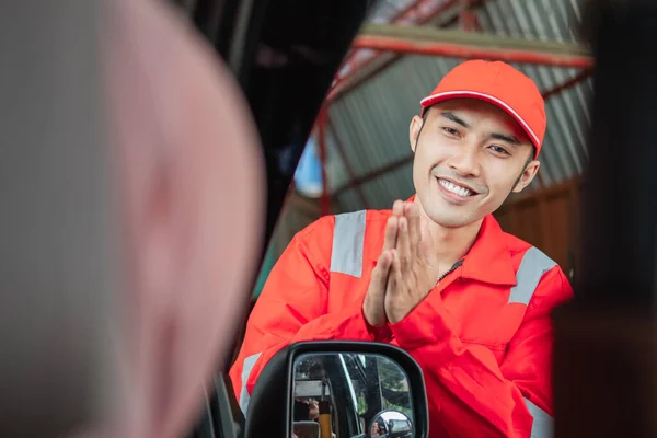 Närbild av mekaniker i röd uniform med en gest av hans hand för att tacka kunden — Stockfoto