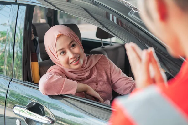 Menutup seorang wanita di kerudung dengan mobil datang untuk disambut oleh montir — Stok Foto