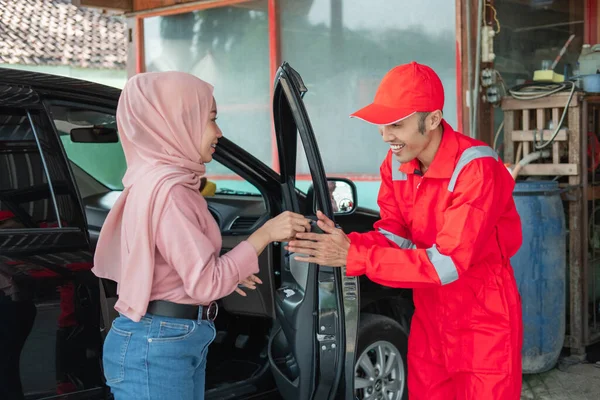 Mekanik berwarna merah menerima kunci mobil ketika pelanggan datang dengan mobil untuk diperbaiki — Stok Foto