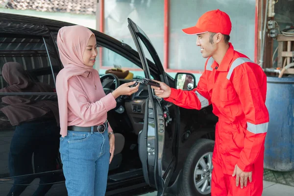 Mechaniker in Rot übergibt den Autoschlüssel nach der Reparatur an den Kunden — Stockfoto