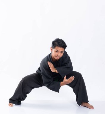 Genç adam dövüşmek için pencak silat spor üniforması giyiyor.