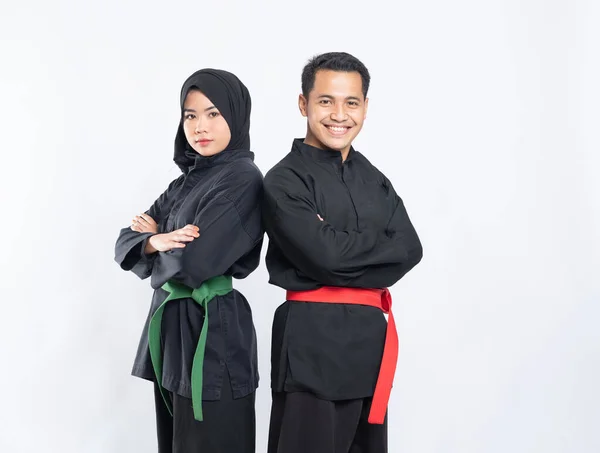 Asiático hombres y mujeres usando pencak silat uniformes stand back to back — Foto de Stock