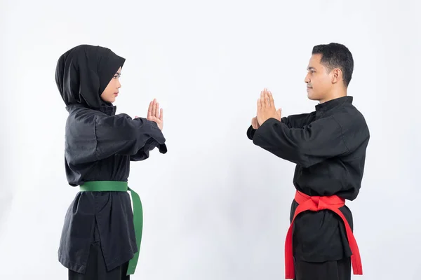 Laki-laki dan perempuan Asia mengenakan pencak silat seragam berdiri berhadapan dengan hormat — Stok Foto