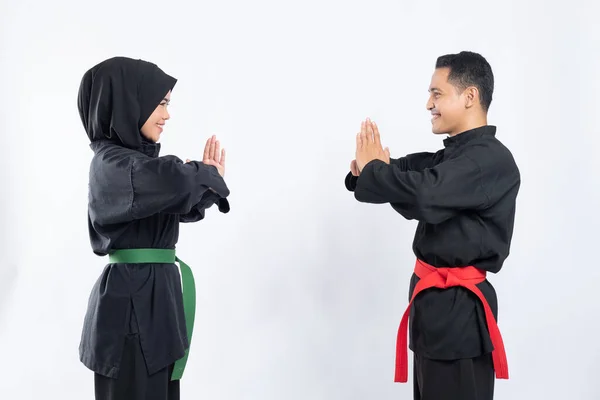 Souriant asiatique les hommes et les femmes portant crayon silat uniformes stand face à face avec respect — Photo