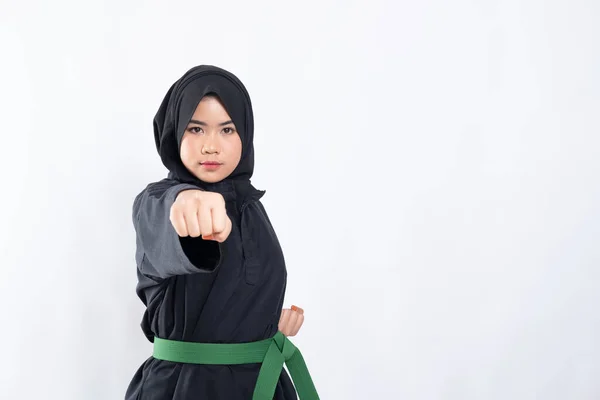 Mujer en hijab en pencak silat uniforme poses golpeando delante con copyspace — Foto de Stock