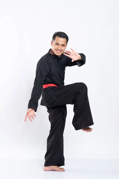 Männer in Pencak-Silat-Uniformen heben ein Bein zur Verteidigung — Stockfoto