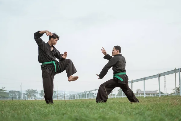 Dos luchadores en pencak silat pose uniforme con posturas —  Fotos de Stock