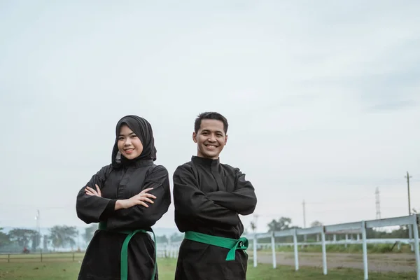 De två asiatiska fighters bär pencak silat uniformer med korsade händer — Stockfoto