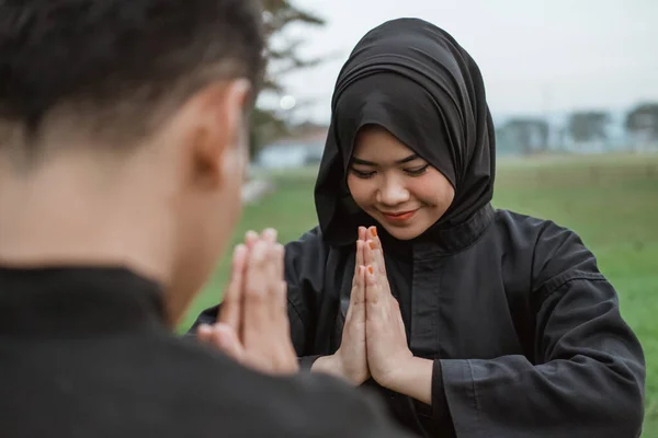 Enfoque selectivo de las mujeres asiáticas que usan hiyabs con uniformes de pencak silat con poses de respeto por sus oponentes — Foto de Stock