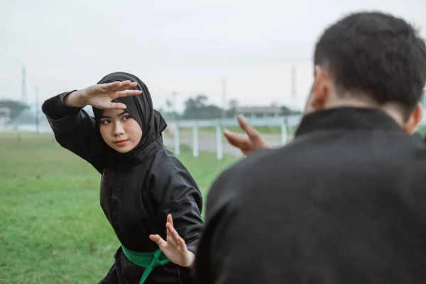 Enfoque selectivo de wanita asia beljilbab memakai seragam pencak silat dengan gerakan frente postura — Foto de Stock
