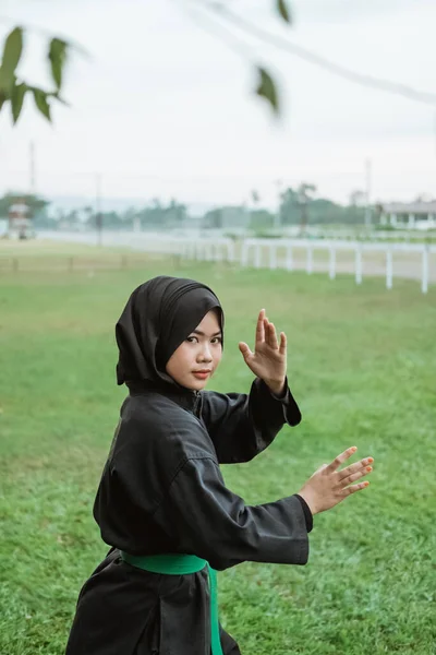 Primer plano de una mujer asiática con velo y un uniforme de pencak silat con una postura lateral — Foto de Stock