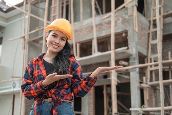 Belles femmes entrepreneurs avec des gestes offrent quelque chose portant un casque de sécurité — Photo