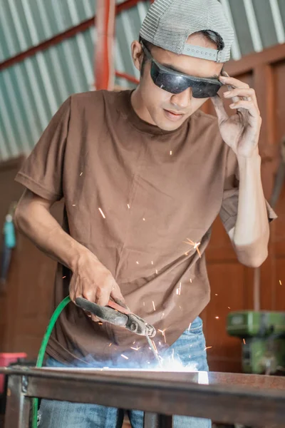 Los soldadores usan gafas de soldadura negras al soldar varillas de hierro —  Fotos de Stock