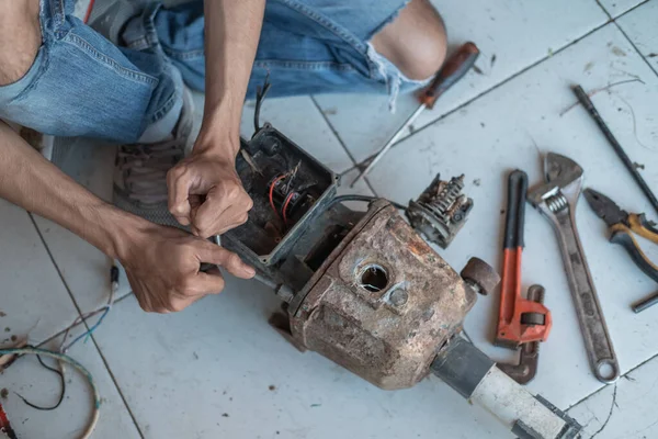 Primer plano de la mano de un trabajador electrónico utilizando una llave de tres cabezas para desenroscar el tornillo —  Fotos de Stock