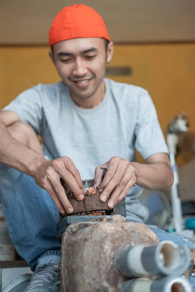 Elektronikarbeiter öffnet und greift Spule während Reparatur Wasserpumpe Maschine — Stockfoto