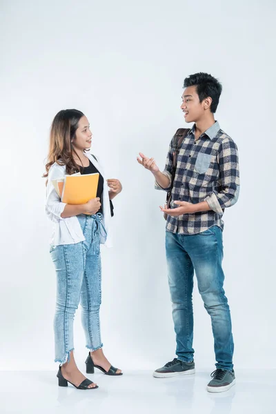 Retrato de conversa amigos universitários carregando um saco e livro — Fotografia de Stock