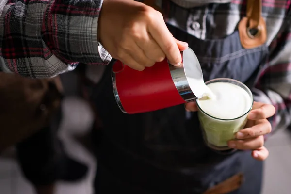 Closeup barista despeje leite em uma xícara de arte latte — Fotografia de Stock