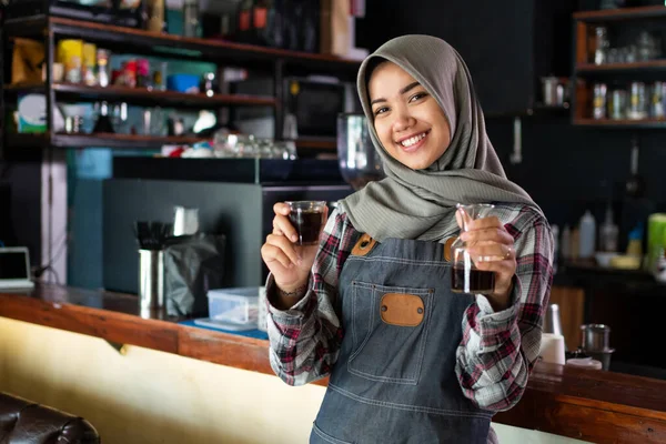 Nahaufnahme einer lächelnden Kellnerin mit einer Tasse Kaffee — Stockfoto