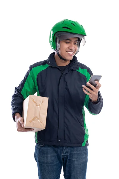 Mannelijke koerier met pakket en het gebruik van smartphone geïsoleerd — Stockfoto