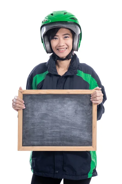 骑摩托车的女出租车司机头戴安全帽，手持空白黑板 — 图库照片
