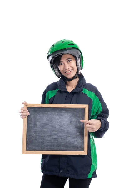Feminino táxi motociclista usando capacete segurando blackboard em branco — Fotografia de Stock