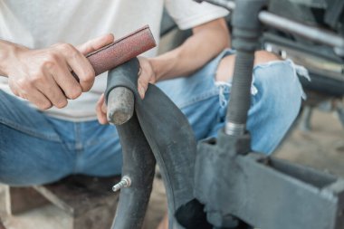 Lastik tamircisinin elini kapat. Sızdıran bir iç boruyu ovala.