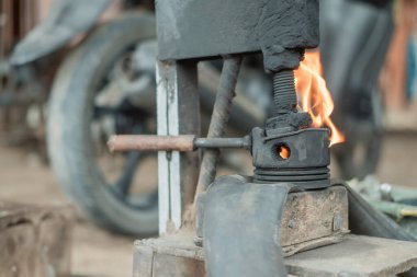 Motosiklet lastiğini tamir ederken geleneksel bir pres makinesinde alevin yan görüntüsü