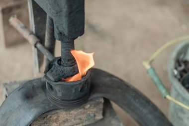 Motosiklet lastiğini yamalarken geleneksel bir basın aracında alevin üst görünümü