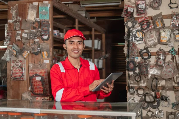 Mecánico sonriente que usa una mochila y un sombrero usando una tableta digital —  Fotos de Stock