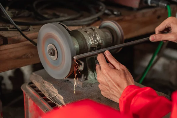 Nahaufnahme mechanischer Hände mit einer Schleifmaschine, um die Enden der Schrauben zu glätten — Stockfoto