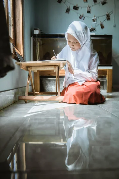 Écolière indonésienne étudiant devoirs pendant sa leçon en ligne — Photo
