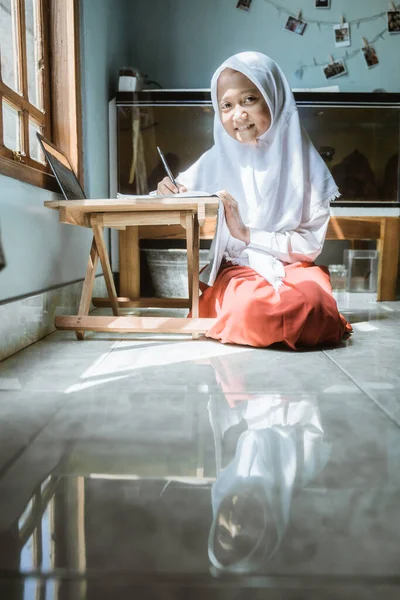 Écolière indonésienne étudiant devoirs pendant sa leçon en ligne — Photo
