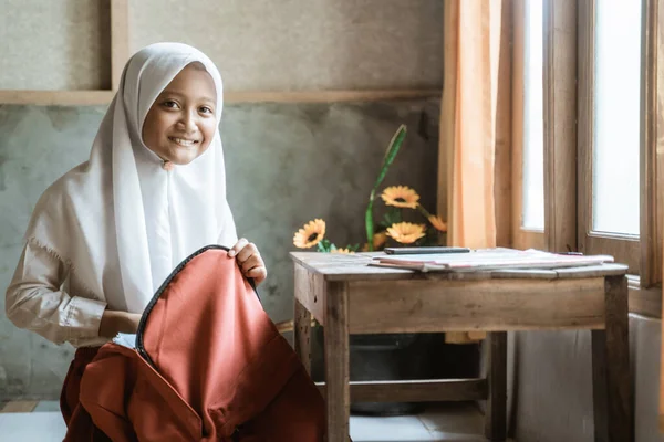 Écolière indonésienne préparant son livre à la maison avant d'aller à l'école — Photo