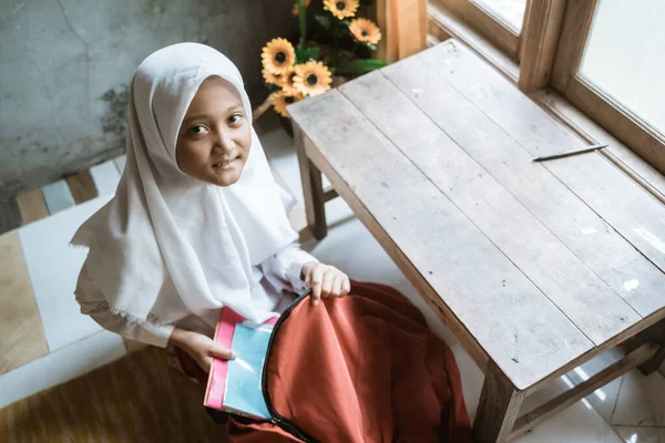 Écolière indonésienne préparant son livre à la maison avant d'aller à l'école — Photo