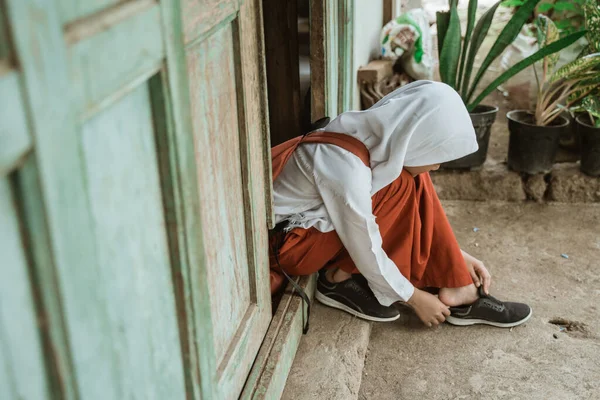 Estudiante de primaria indonesia preparándose para la escuela por la mañana — Foto de Stock