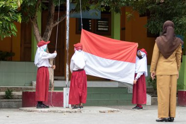 Student raising Indonesian flag