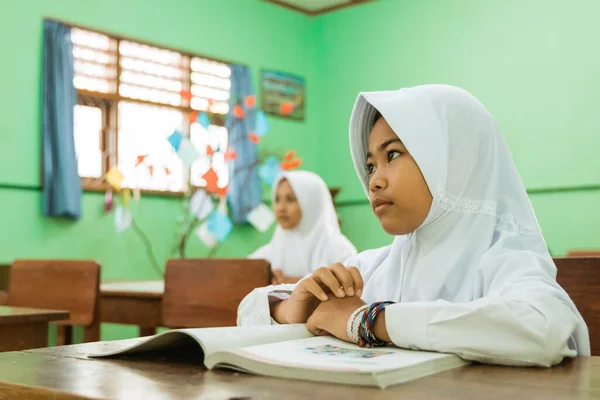 Portrait d'une étudiante musulmane indonésienne regardant son professeur enseigner — Photo