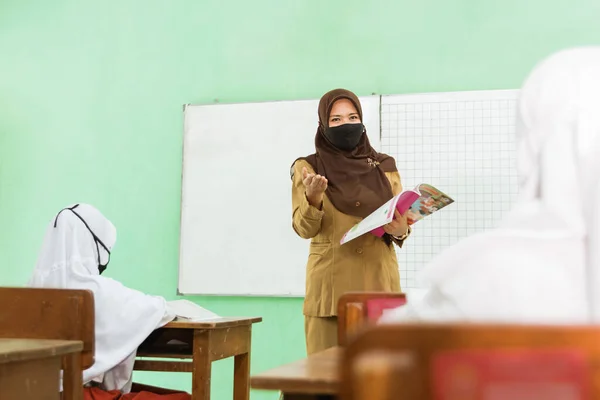 Potret kegiatan mengajar guru muslim Indonesia memakai topeng — Stok Foto